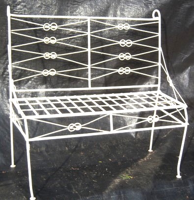 From Garden Room Style The Wrought Iron Bow Knot Bench from A Rustic Garden 