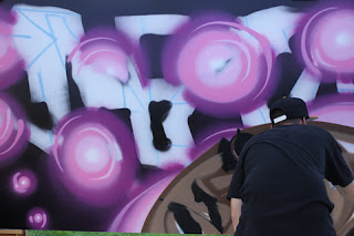 Graffiti Artist Palyn using multiple shades of purple, dark olive and ice blue.