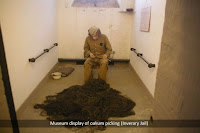 Museum display of prisoner picking oakum in a cell.