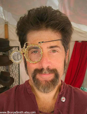 Brass metal steampunk monocle with articulated magnifying lens that opens and closes. Steampunk metal mask or eyepatch