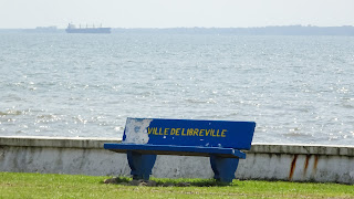 Blue bench with yellow letters is visible often in the city