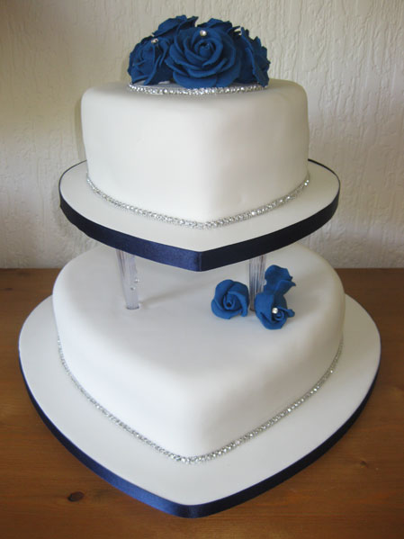 Heart white wedding cake with diamontes and dark blue sugar roses