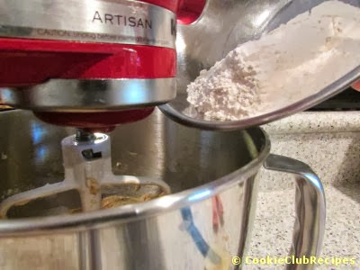 adding flour to mixing bowl