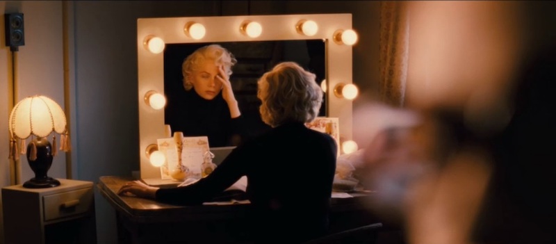 Williams as Marilyn sitting at vanity, its mirror surrounded by bulbs