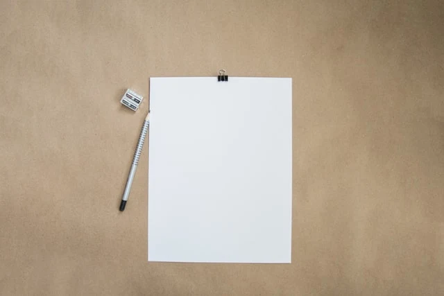 A stock image of a white piece of paper, pencil and pencil sharpener