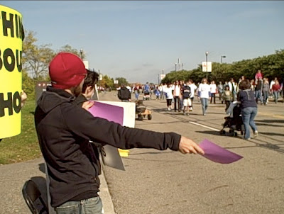 Tim Jensen holds out a purple flyer to the walkers