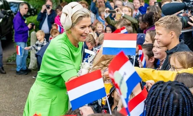 Queen Maxima wore a new green midi dress by Natan, and beige trench coat by Max Mara. Green earrings