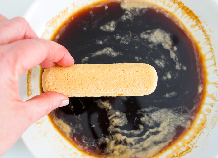 dipping ladyfingers in coffee and liqueur, for tiramisu