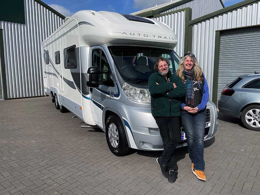 Samantha and Adam standing next to their motorhome
