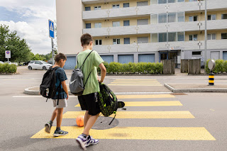 Jugendliche überqueren auf dem Schulweg die Strasse