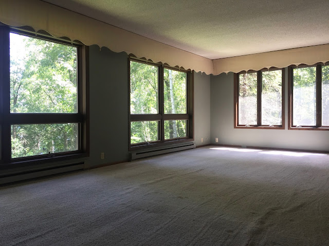 Minnesota lakeside mountain cabin home living room renovation before with floor to ceiling windows facing the lake and custom curtains