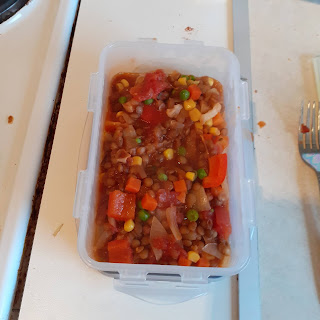 A Tupperware container with vegetable bolognese in it.
