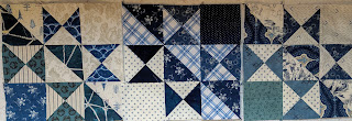 The first three blocks in a variety of blue and white prints laid out on the design wall