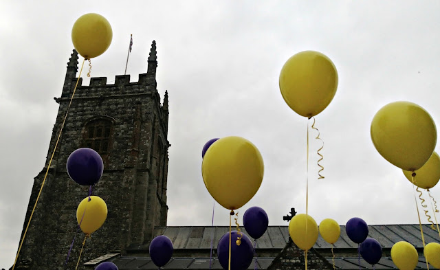 Purple and yellow balloons with church behind