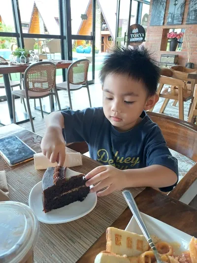 Rafa eating a chocolate cake at Istorya Cafe in Purico’s Cabin Resort