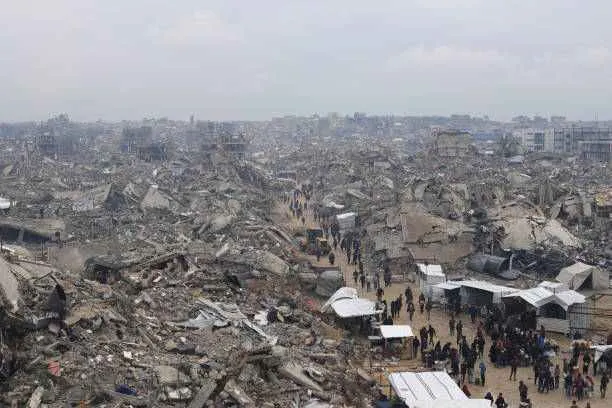 An aerial view shows Palestinians walking through the ruins of destroyed buildings in Jabalia refugee camp in the northern Gaza Strip on February 5, 2025. Photo by Khalil Ramzi Alkahlut/Anadolu/Getty Images