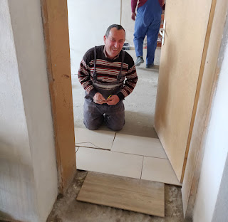 Bekir happily laying tiles