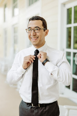 groom in white shirt fixing his black tie