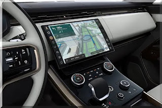 A imagem mostra o painel moderno do Range Rover Sport 2023, com destaque para a central multimídia e o volante multifuncional.