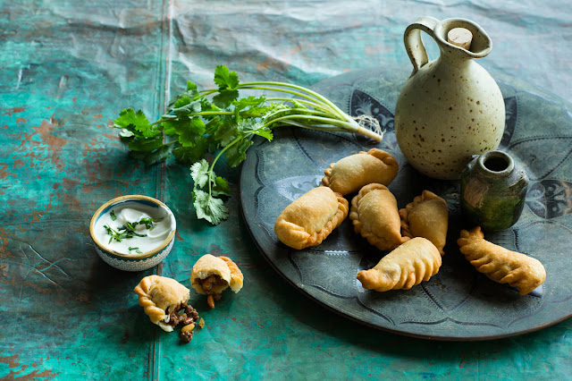 Sambousik, parsley in a serving dish and dipping sauce bowl