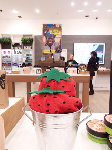 The Body Shop strawberry shower caps, displayed in tin buckets.