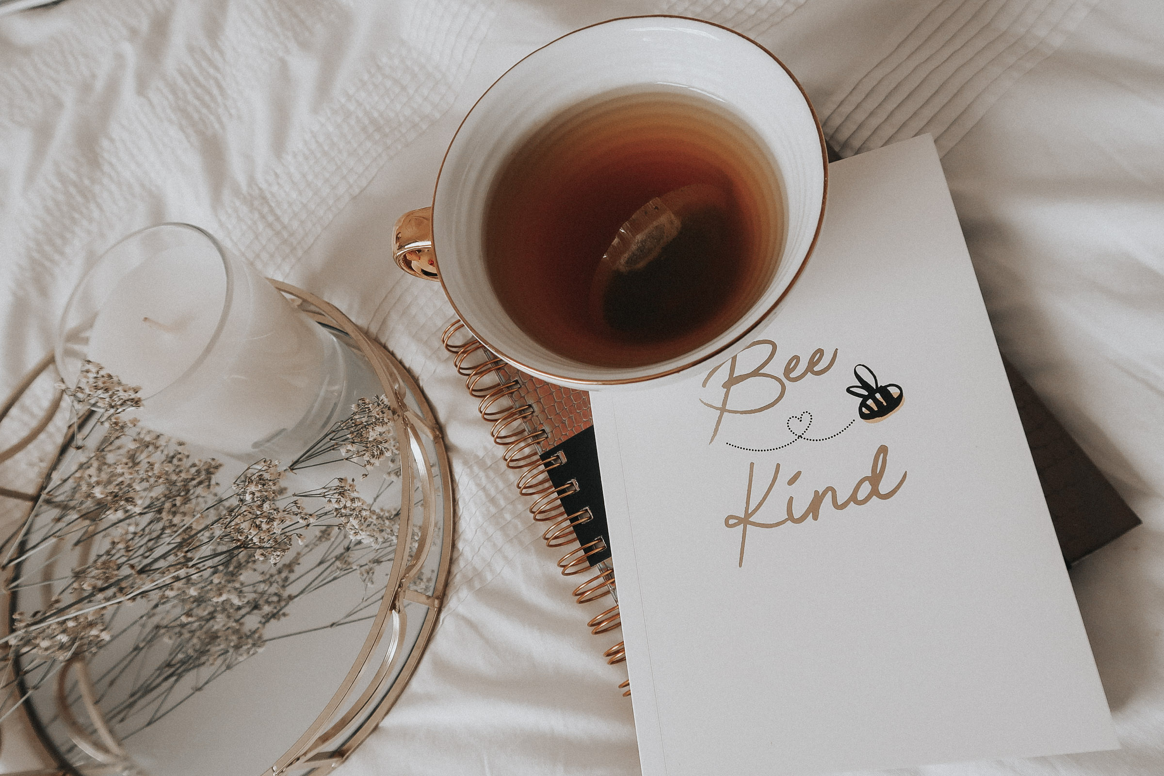 A flatlay of a white notebook and white mug