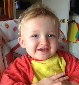 toddler smiling with ketchup on face