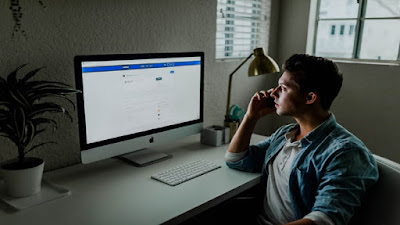 Lone worker in a home business station looking at a computer screen.