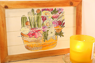 Wooden board with succulent rub on transfer design near candle on a table