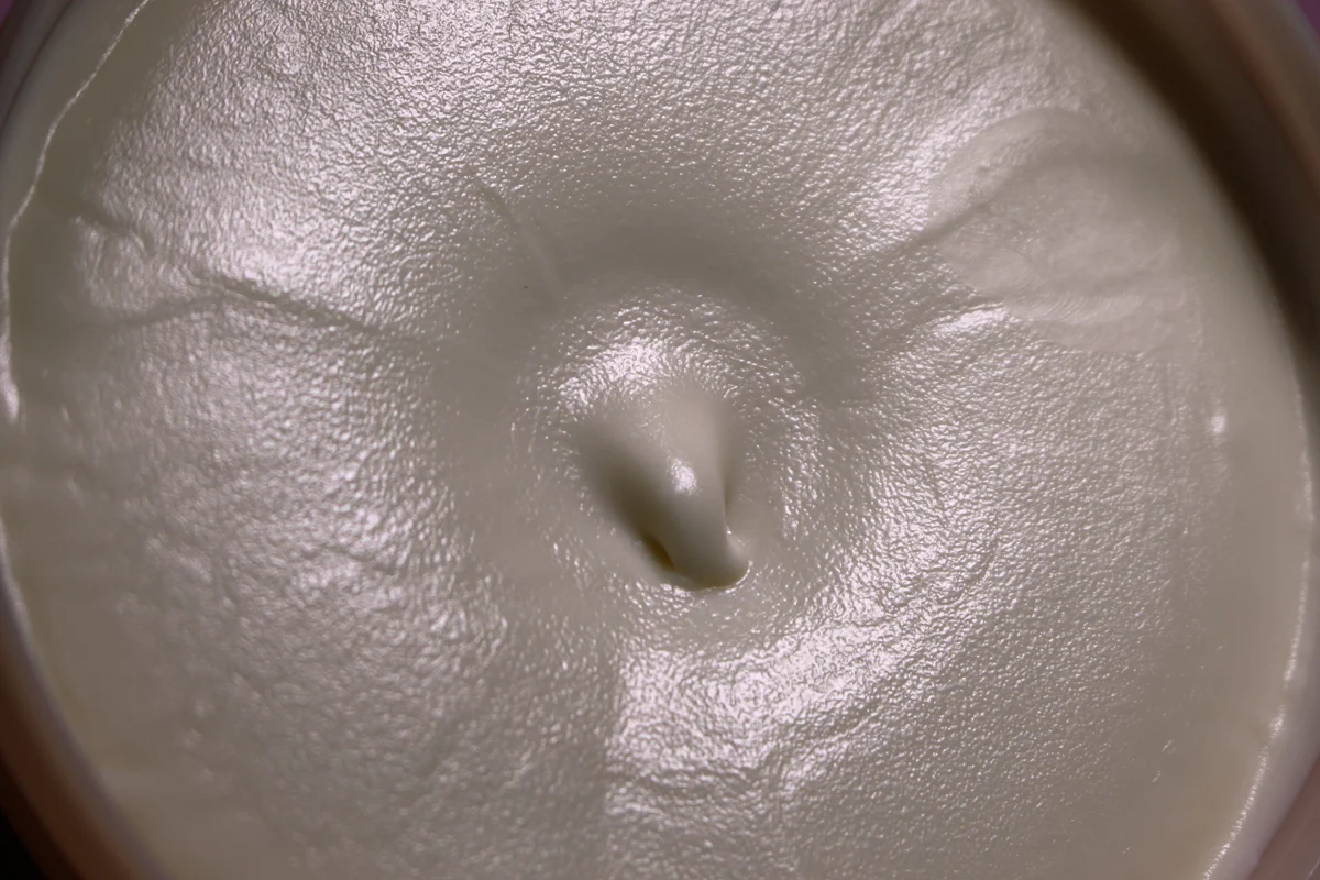 close-up shot of an opened pot with the Nourishing Body Butter by The Body Shop showing the texture of the product