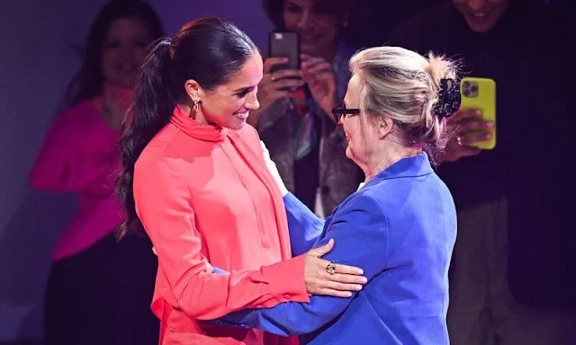 Meghan Markle wore a fire red bow blouse by Another Tomorrow, and classic trouser by same brand. Aquazzura red court shoes