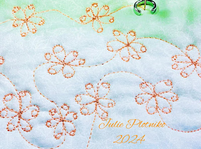 Orange machine stitching on white fabric.