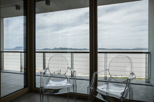 Two glass chairs by the window 