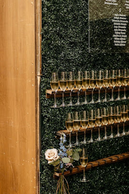 champagne wall and seating chart on greenery hedge wall
