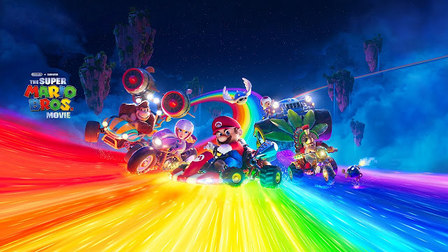 Imagem de Super Mario Bros.: O Filme com Mario, Peach, Donkey Kong, Toad e Cranky Kong pilotando veículos na Rainbow Road. Há um Casco Azul sobrevoando eles.