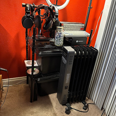 The wire shelves, storage boxes, Tokyyo60 keyboards, headphones on stand, and radiator.