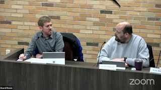 Screen shot from the 12/18/23 village board meeting showing Trustee McPherson making a presentation while Trustee Zitzelsberger reacts with agreement