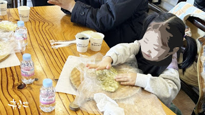 Participants holding takeout boxes with their handmade pizzas after the farm experience