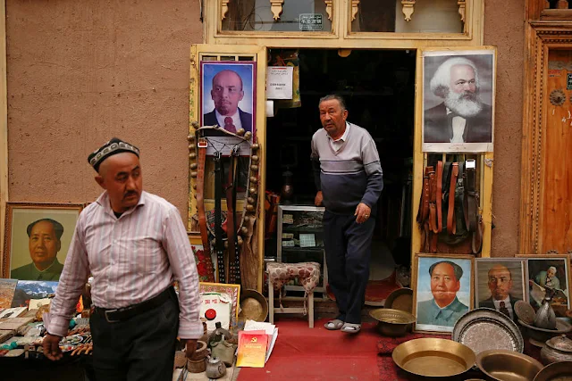 Image Attribute:  Portraits of China's late Chairman Mao Zedong, Soviet state founder Vladimir Lenin and German philosopher Karl Marx are displayed outside an antique shop in the old town in Kashgar, Xinjiang Uighur Autonomous Region, China, March 22, 2017.  REUTERS/Thomas Peter