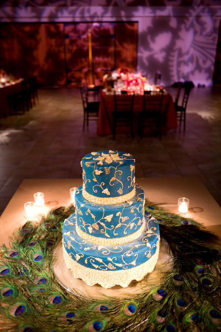 Blue wedding cake set over three tiers surrounded by beautiful peacock 