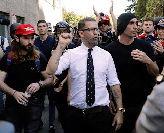 Gavin McInnes, center, founder of the far-right group Proud Boys, is surrounded by supporters after speaking at a rally in Berkeley, Calif. McInnes and his Proud Boys group have been banned from Facebook and Instagram because of policies prohibiting hate groups.(AP Photo/Marcio Jose Sanchez, File)