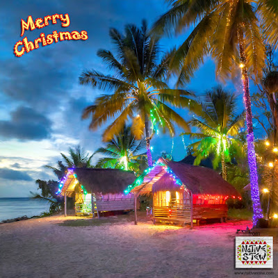 wooden village houses on tropic beach at dusk with christmas lights