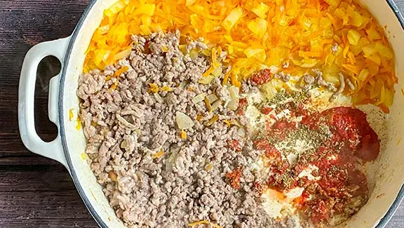 Making bolognese sauce in a large frying pan.