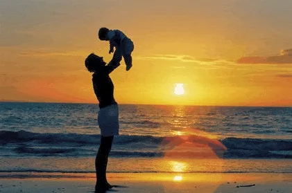 Padre con bebé en la playa.
