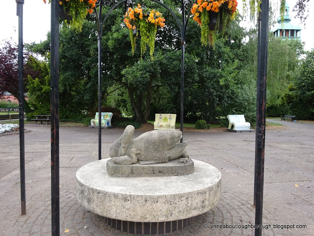 Stone sculpture of a swan in an iron fromed gazebo