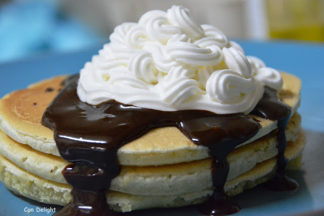 panckes with mountain of cream and chocolate sauce