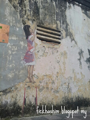 mural girl on stool by ernest zacharevic in ipoh