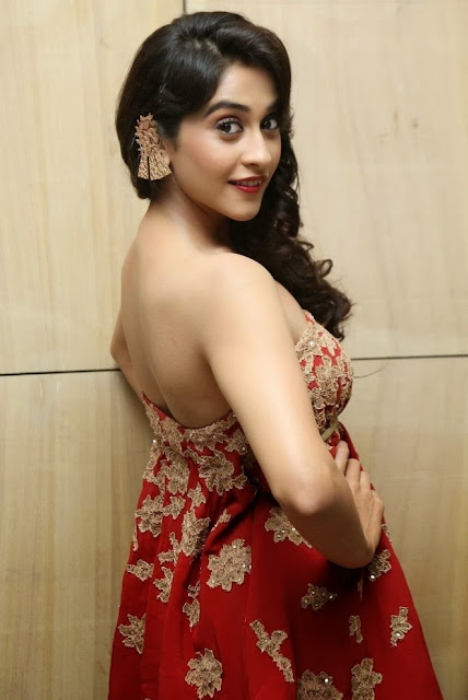 "Regina Cassandra exudes grace in a sleeveless red dress, a vision of elegance and charm.