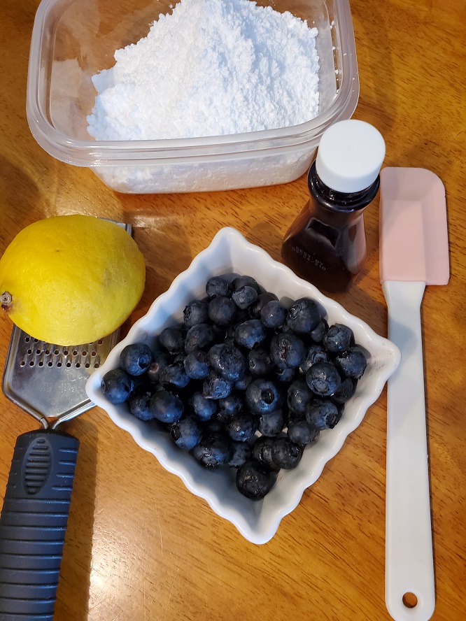 this is lemon zest and zester, blueberries and other tools needed to make blueberry drop cookies