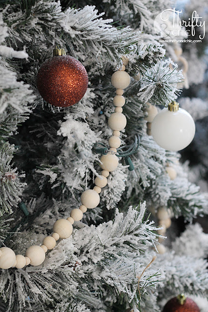 Neutral Christmas living room decor. Wood and white Christmas decor. Boho style Christmas decor. Bohemian style Christmas tree. Beaded and macrame Christmas tree decor and decorating ideas. How to decorate a Christmas tree. Farmhouse style Christmas decor. Wood and White Christmas mantel decor. Vintage Christmas mantel ideas. Flocked Christmas trees. Two story living room design.